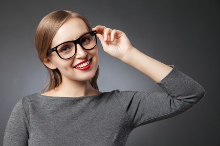 Portrait of beautiful smiling woman in glasses with red lipsの写真素材