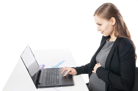 Side view of smiling pregnant woman working on laptop.Studio shotの写真素材