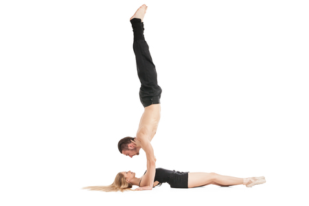 Gymnast in handstand above woman lying on floor.Isolatedの写真素材