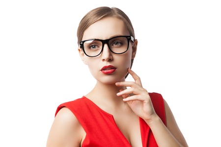 Portrait of successful confident woman in glasses and red dress with red lipstick on looking awayの写真素材