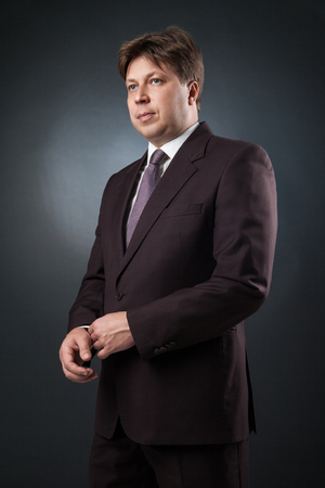 Portrait of adult businessman in suit and tie looking away.Studio shotの写真素材