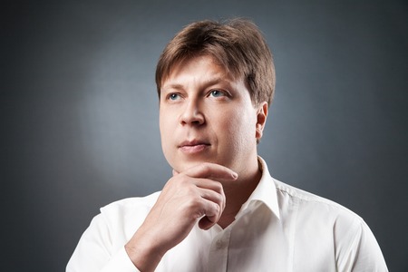 Portrait of thoughtful adult man looking away against of black background.Isolated.Studio shotの写真素材