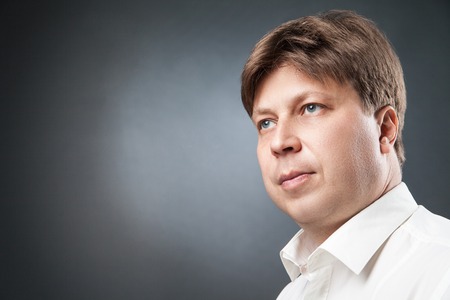 Portrait of serious adult businessman looking away.Black backgroundの写真素材