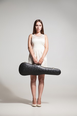 Portrait of attractive musician with violing case.Studio shotの写真素材