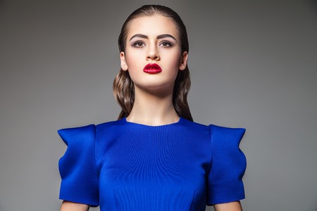 Portrait of beautiful woman in blue dress with bright make-up.Studio shotの写真素材