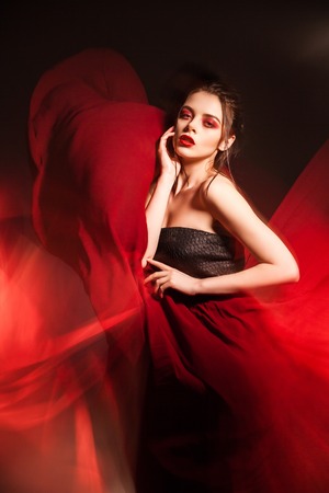 Portrait of sensual attractive model with make-up in waving red dress.Long exposureの写真素材