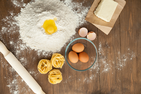 Cooking some tasty food. With ingredients like butter, eggs, flour, pasta. View from aboveの写真素材