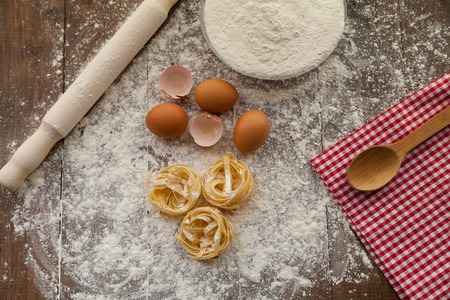 Cooking some delicious thing with chicken eggs, flour and pasta. View from above.の写真素材