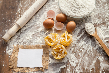 Cooking some delicious thing with chicken eggs, flour and fettuccine. View from above.の写真素材