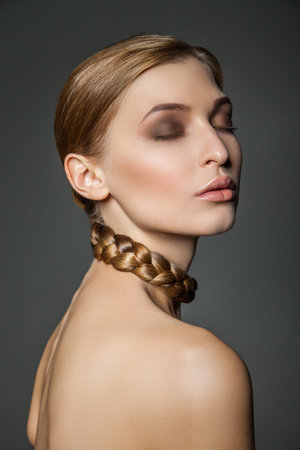 Beautiful young woman with hair around her neck. Vertical studio shot