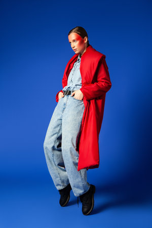 Trendy female dancing on tiptoes against blue backgroundの写真素材
