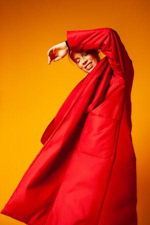 Female model in baggy coat and dancingの写真素材