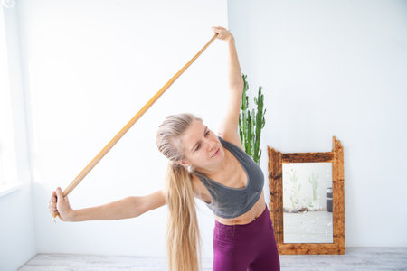 Happy female athlete exercising with elastic bandの写真素材