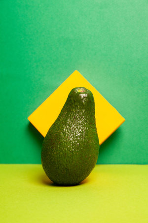 Whole ripe green avocado against two color background