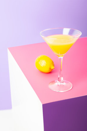 Refreshing yellow lemon cocktail in glass on tableの写真素材