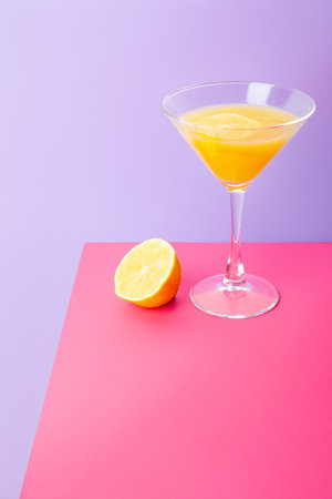Refreshing yellow lemon cocktail in glass on tableの写真素材