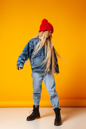 Trendy woman in denim clothes and knitted hatの写真素材
