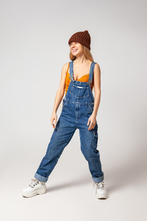 Energetic hipster woman in trendy wear dancing in studioの写真素材