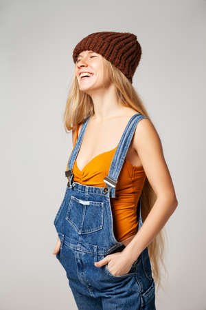 Positive hipster woman in trendy outfit against white backgroundの写真素材