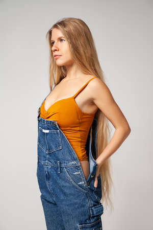Positive hipster woman in trendy outfit against white backgroundの写真素材