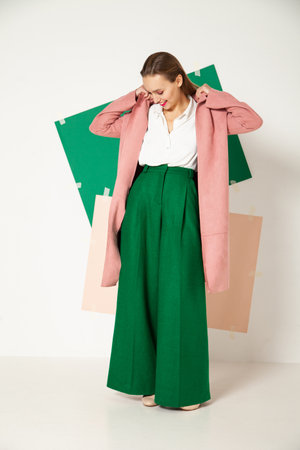 Elegant woman in stylish colorful wear in studio with white backgroundの写真素材