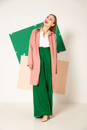 Elegant woman in stylish colorful wear in studio with white backgroundの写真素材