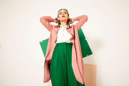 Elegant woman in stylish colorful wear in studio with white backgroundの写真素材