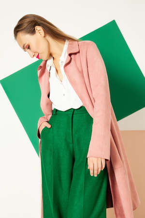 Elegant woman in stylish colorful wear in studio with white backgroundの写真素材