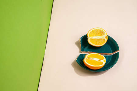 Pieces of fresh orange on broken plateの写真素材