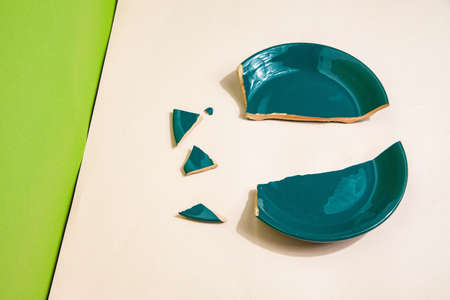 Pieces of broken plate on table in studioの写真素材