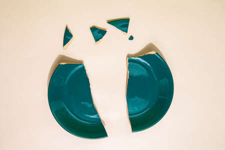 Pieces of broken plate on table in studioの写真素材