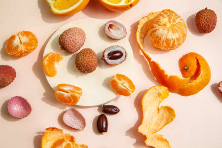 Tasty lychees and oranges arranged on pink tableの写真素材