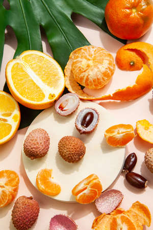Tasty lychees and oranges arranged on pink tableの写真素材