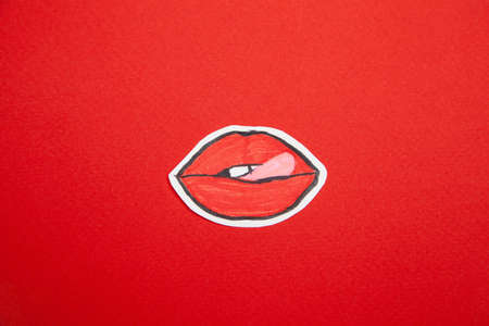Painted red lips with tongue out on bright surfaceの写真素材