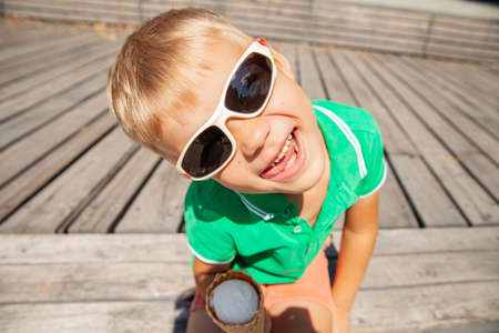 Playful preschooler with ice cream cone showing tongueの写真素材