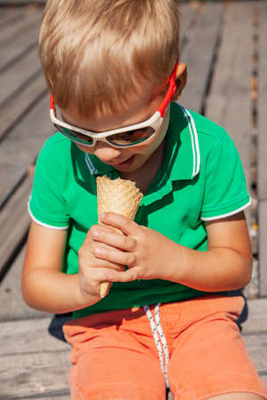 Cute little kid in sunglasses eating ice creamの写真素材