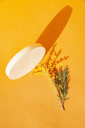 Round board with twigs near blooming plant
