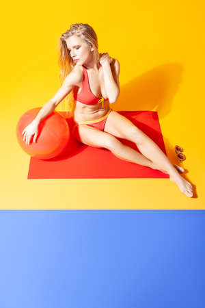 Woman in bikini with inflatable ball in studioの写真素材