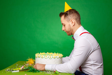 Sad man with birthday cake in studio