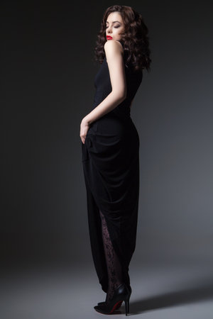 Gorgeous young woman posing in black dress and looking at camera.の写真素材