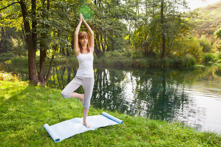 Young girl doing yoga in the parkの写真素材