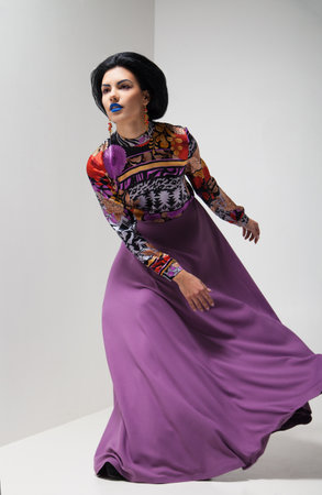 Fashion photo of young magnificent woman in purple dress. Studio photoの写真素材