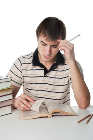 Male student at the table with a pile of books over whiteの写真素材