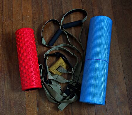 Home training equipment: suspension straps, red foam roller, blue sport matの写真素材
