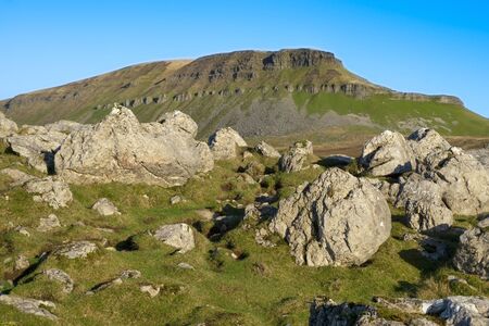 A dramatic low angle sot of Penyghent lit by autumn able sunsetの写真素材