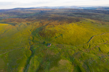 An aerial Sunrise drone shot of Top Withens or Top Withins, this farmhouse has been associated with