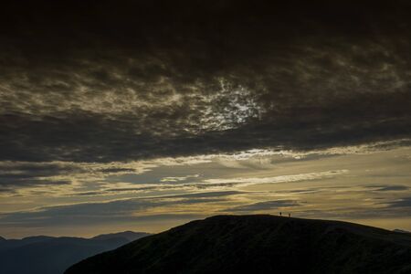 Two walkers reach the top of Blease fell in the Lake Districtの写真素材