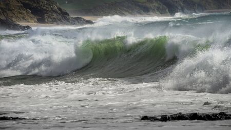 Waves crash on to the rocks and beaches of a cornish coastline, UKの写真素材