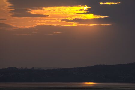 Sunset over Morecambe Bay the largest estuary in northwest England, just to the south of the Lake District National Park. It is the largest expanse of intertidal mudflats and sand in the United Kingdom,の写真素材