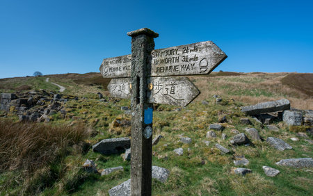 A footpath sign in english and japanese giving directions to Top Withens Haworth or Withins